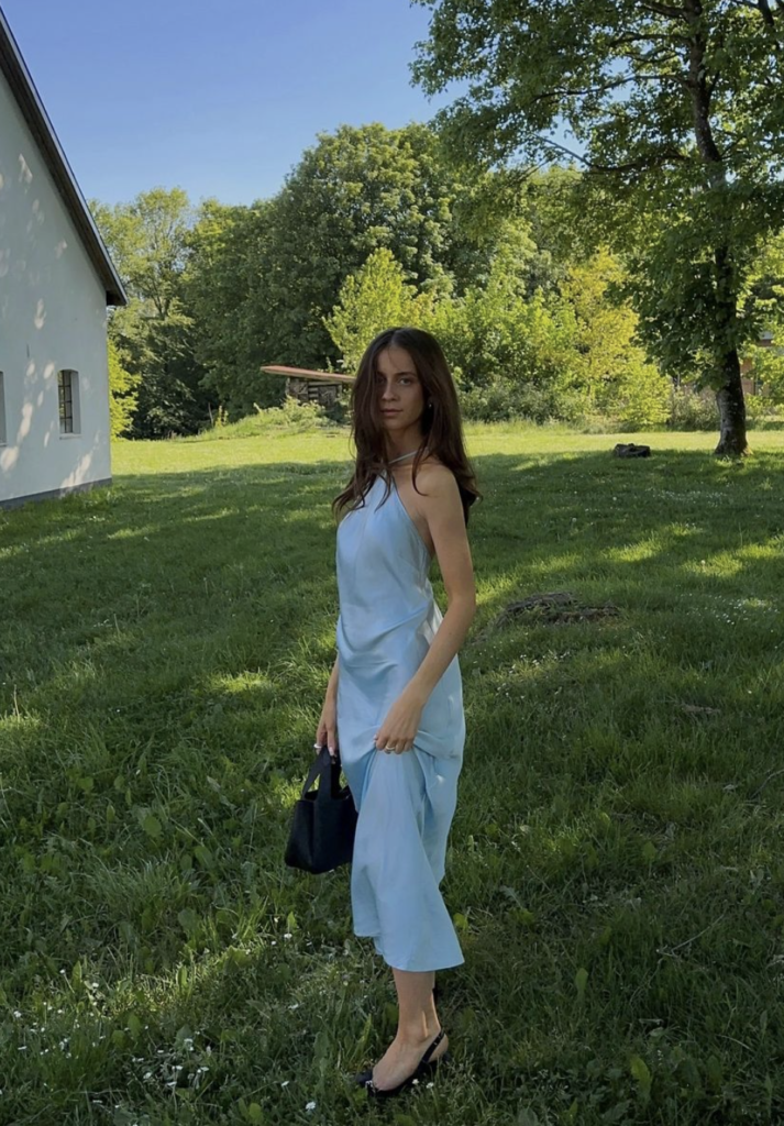 Light blue midi dress summer brunch outfit with black heels in a sunny outdoor setting.